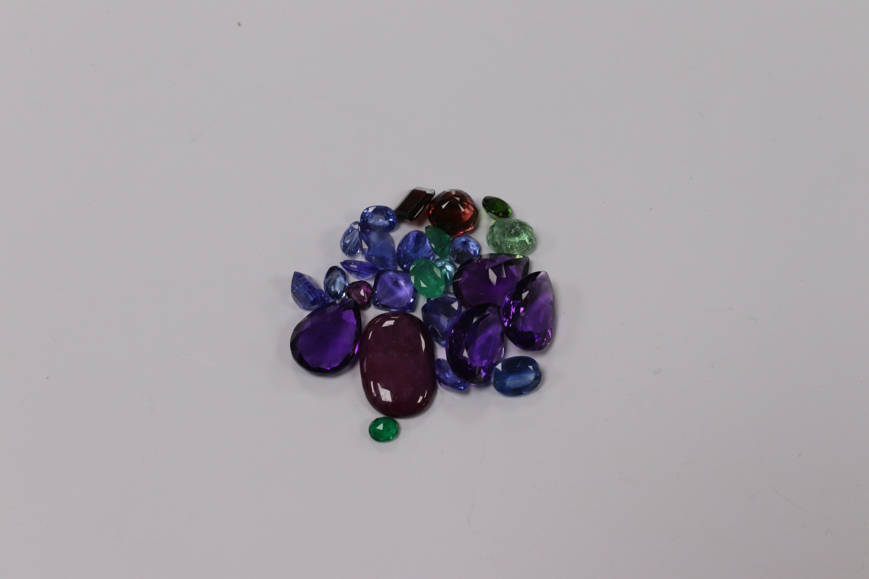 A small collection of unmounted cut gemstones, including amethyst, emerald and ruby, etc. Condition - fair